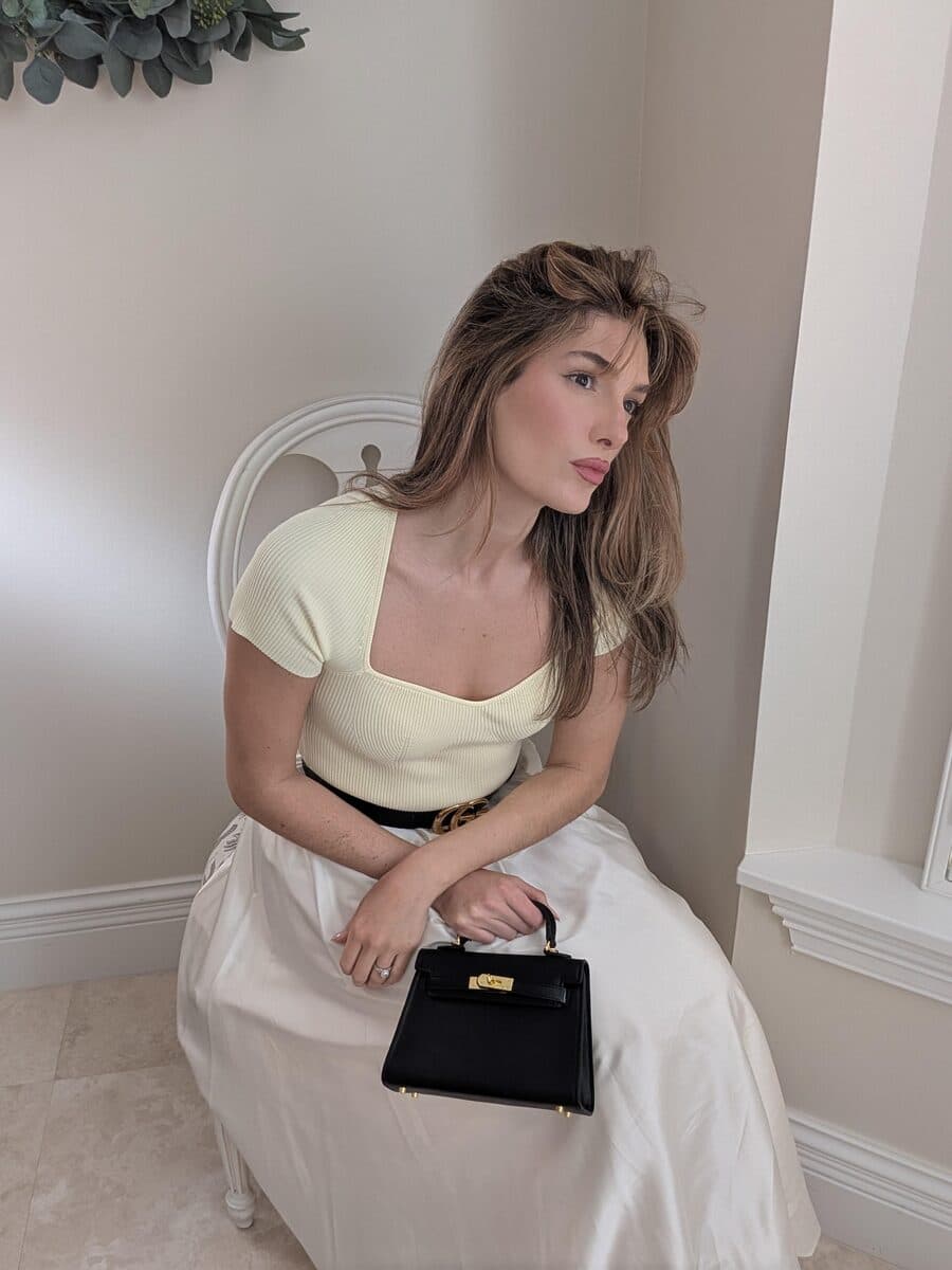Seated portrait with a black top-handle bag